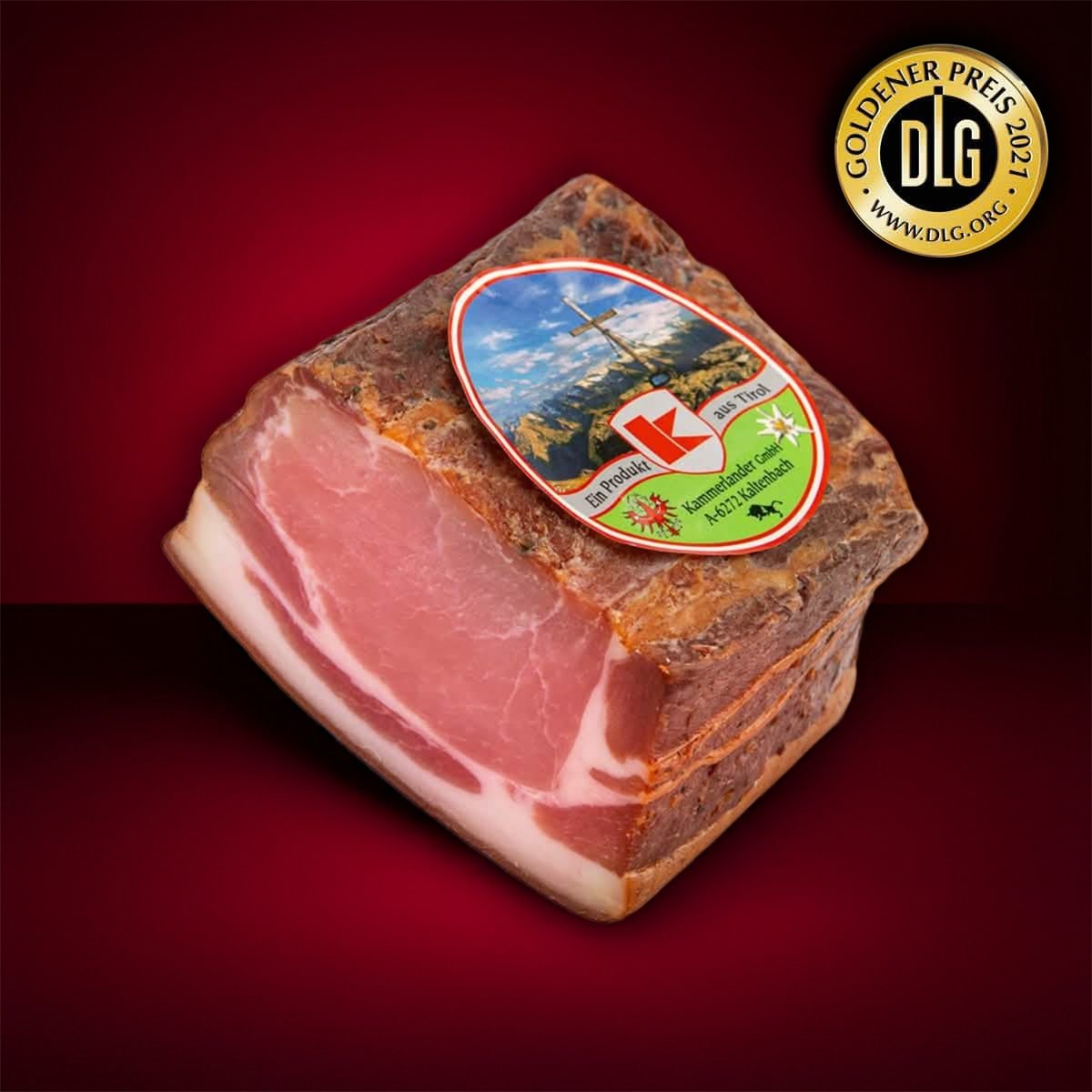 Angeschnittener Speck mit Etikett und Goldener Preis-Auszeichnung auf dunklem Untergrund.