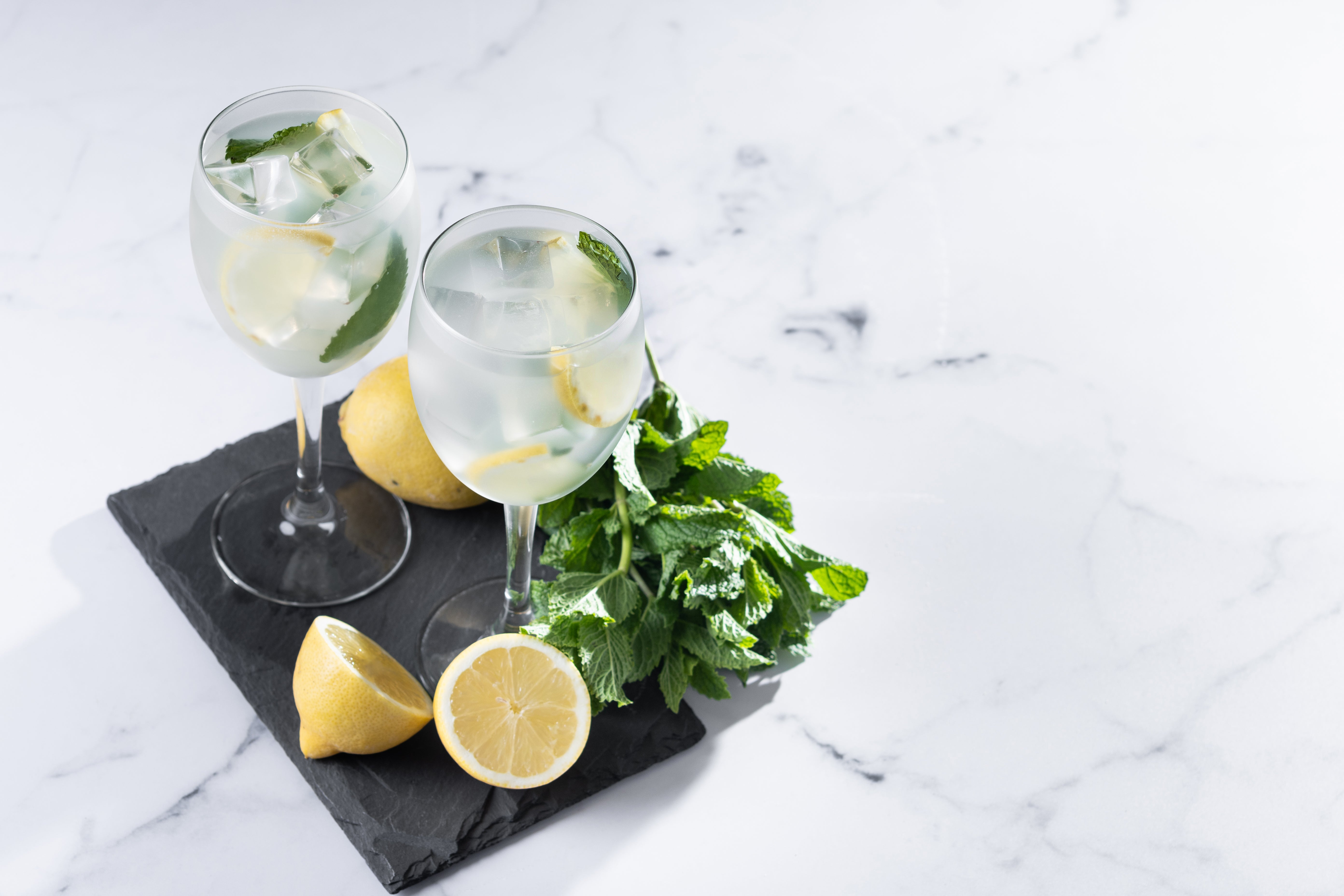 Hugo Spritz Cocktail mit Minze und Limette auf Schieferplatte